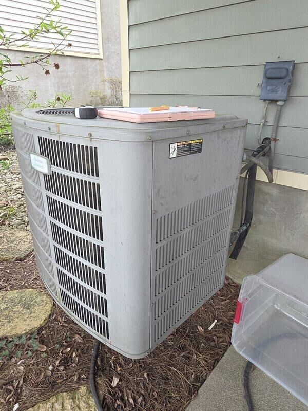 Conducted estimate for replacement of 20-year-old residential air conditioning system utilizing R-22 refrigerant with identified leak in outdoor condenser coil. Inspected existing condenser unit positioned on concrete pad against building foundation, documented equipment condition and surrounding installation area, and assessed system for replacement due to age and refrigerant leak rendering repair economically unfeasible.