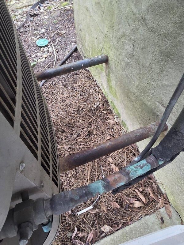 Conducted estimate for replacement of 20-year-old residential air conditioning system utilizing R-22 refrigerant with identified leak in outdoor condenser coil. Inspected existing condenser unit positioned on concrete pad against building foundation, documented equipment condition and surrounding installation area, and assessed system for replacement due to age and refrigerant leak rendering repair economically unfeasible.