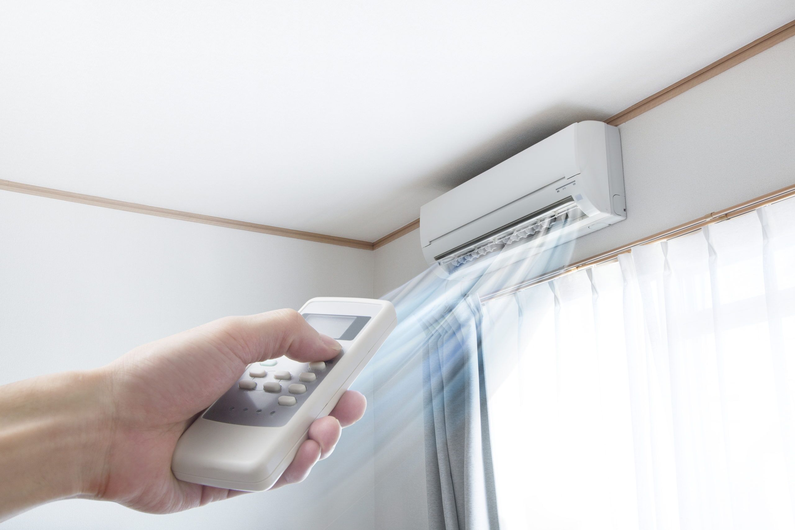 Ductless mini-split mounted on a wall above a window