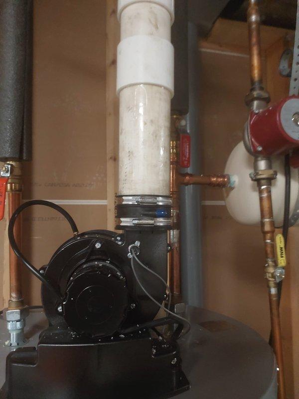 Returned to address inspection corrections on HVAC installation. Replaced improper rubber coupling on water heater blower with approved straight pipe section to meet code requirements. Installed missing gasket and hex screw on furnace as documented in previous inspection photos.