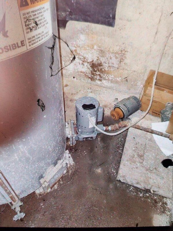Cincinnati, OH - Responded to a no heat complaint at commercial boiler installation. Upon inspection, found significant water damage and deterioration on cylindrical tank, with visible moisture damage to surrounding walls. Identified electrical pump/motor issues connected to the system. Noted overall poor condition of equipment with concrete floor showing water staining and possible mold development on adjacent surfaces.