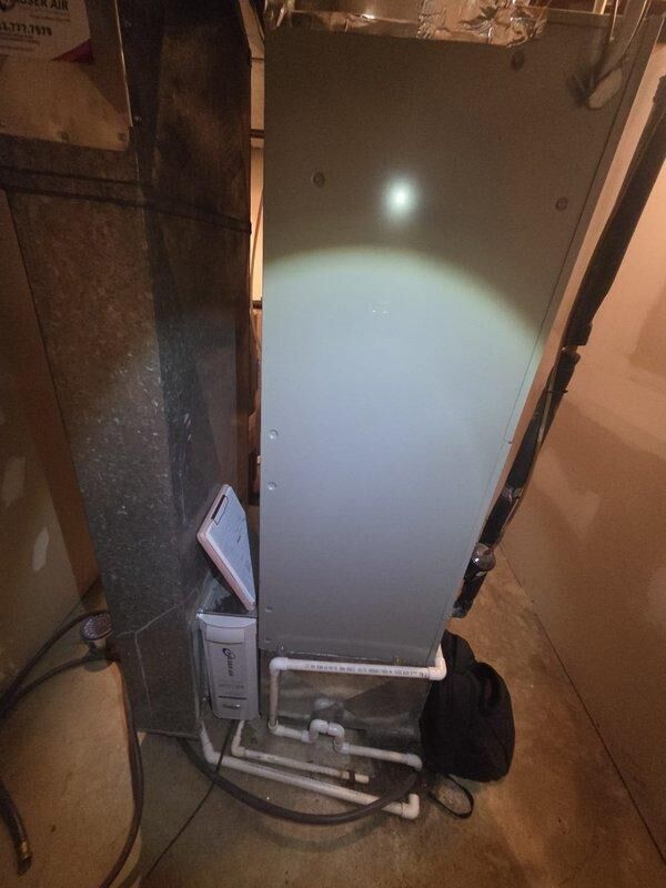 Conducted comprehensive assessment of existing HVAC system for potential replacement, including detailed inspection of furnace unit with connected ductwork and adjacent humidifier system. Documented current installation configuration with photographs, noting PVC drainage components, electrical connections, and overall condition of the heat pump and air handler setup in preparation for replacement estimate.