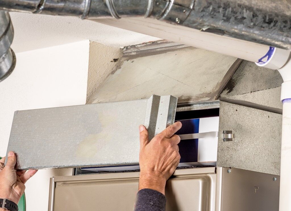 HVAC technician removing panel to change an air filter