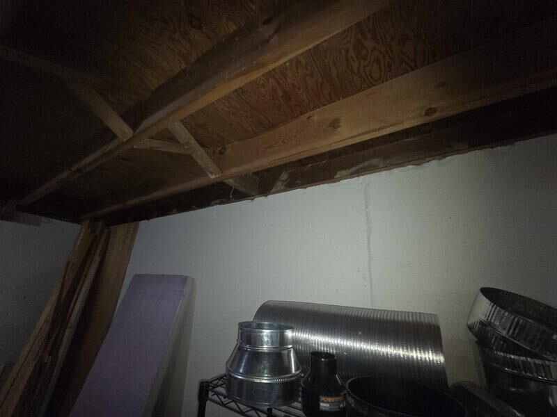 Conducted comprehensive assessment for HVAC system replacement in basement utility area. Evaluated existing ductwork components and connections, noting metal cylindrical ducts with ribbed texture and round connectors requiring replacement. Documented current system configuration including proximity to water heater and other mechanical systems, with attention to ceiling clearance and existing utility connections for proper sizing of replacement unit.