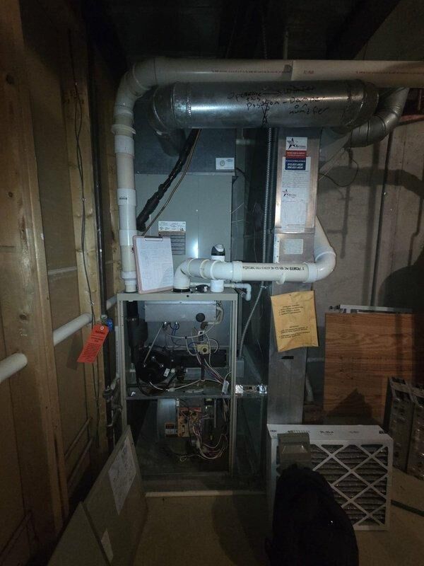 Conducted evaluation of aging HVAC system including a Honeywell Chronotherm IV Plus thermostat and basement-installed furnace unit with exposed internal components, ductwork, and PVC venting. Provided replacement estimate for complete system upgrade based on observed equipment condition and performance assessment.