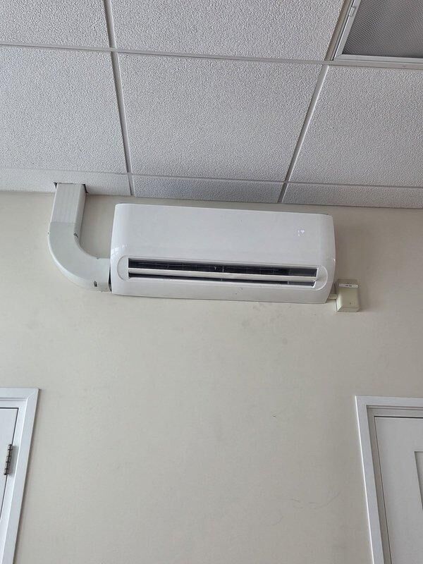 Conducted a commercial HVAC replacement estimate, focusing on a wall-mounted mini-split system. Documented existing conditions including the installation environment and current unit placement near the ceiling with PVC line cover housing refrigerant lines, power, and drainage pipes. Photos were taken to support the estimate documentation for future reference.