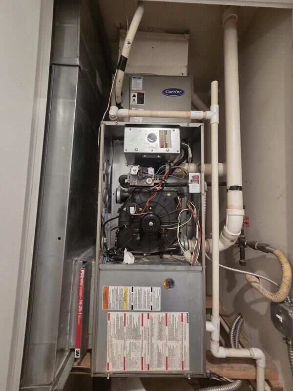 Conducted comprehensive on-site assessment for furnace replacement in residential mechanical closet. Evaluated existing Carrier gas furnace system, documenting current installation configuration including blower motor assembly, electrical connections, control boards, and internal components. Photographed exposed internal systems showing existing wiring infrastructure, PVC venting arrangement, and ductwork connections. Assessed mechanical room layout with vertically stacked HVAC equipment and water heater to determine replacement unit specifications and installation requirements. Provided detailed replacement estimate based on current system configuration and space constraints.