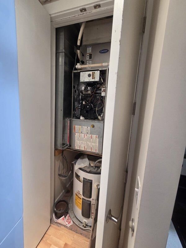 Conducted comprehensive on-site assessment for furnace replacement in residential mechanical closet. Evaluated existing Carrier gas furnace system, documenting current installation configuration including blower motor assembly, electrical connections, control boards, and internal components. Photographed exposed internal systems showing existing wiring infrastructure, PVC venting arrangement, and ductwork connections. Assessed mechanical room layout with vertically stacked HVAC equipment and water heater to determine replacement unit specifications and installation requirements. Provided detailed replacement estimate based on current system configuration and space constraints.