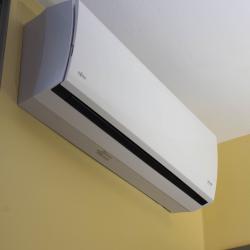Ductless mini split system mounted on a yellow wall