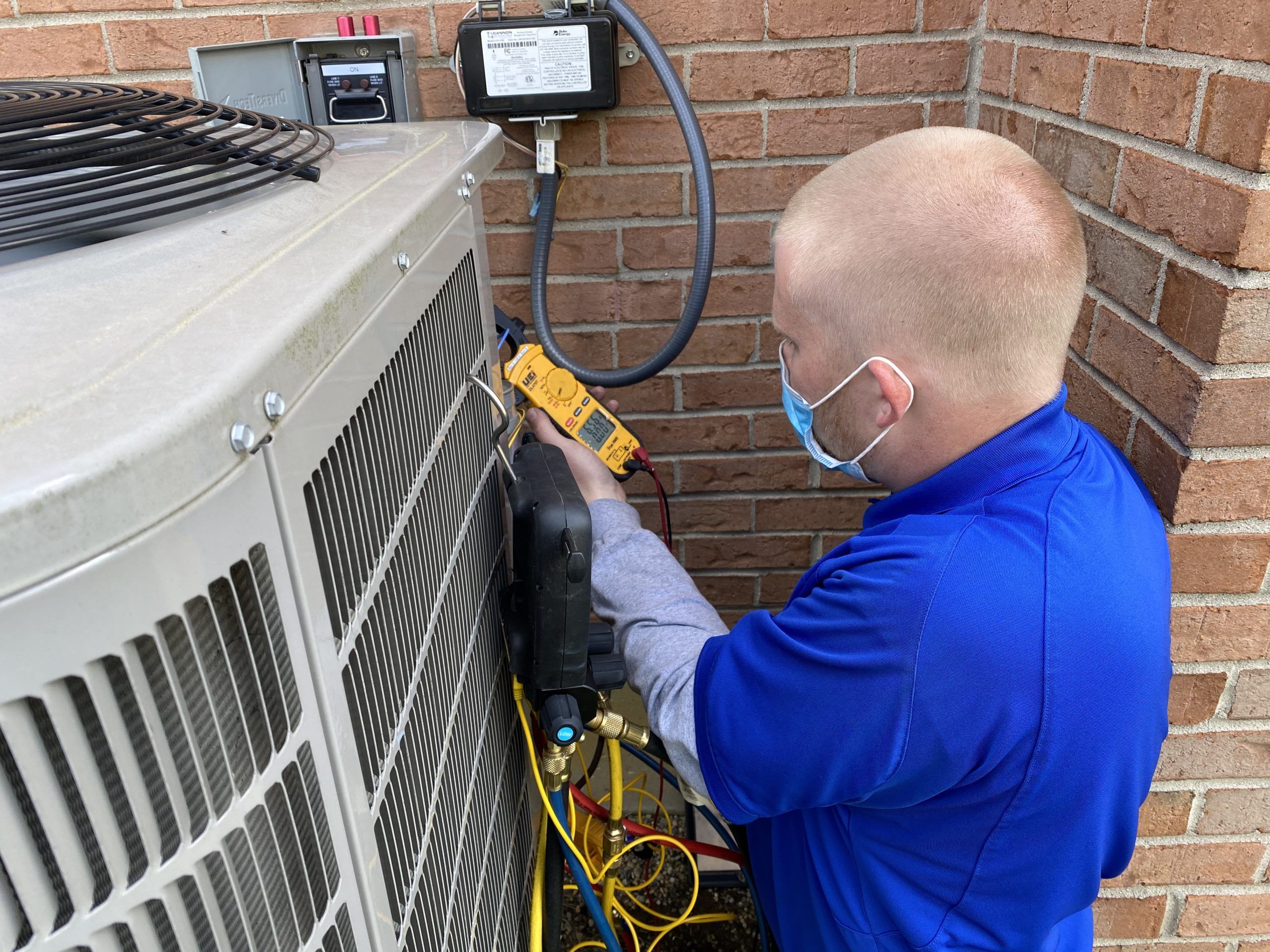 A National technician conducting a maintenance check on an air conditioner